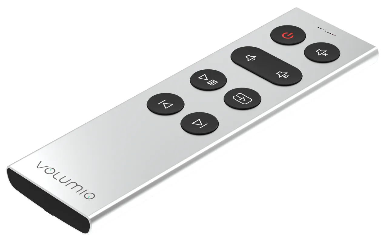 Volumio Remoto seen at an angle: a slim, silver aluminum remote with seven black buttons, one of them wide, near one end, and the Volumio name printed near the other.