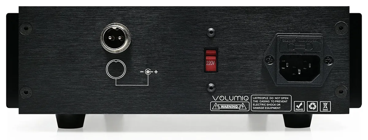 The back of Lineo5, from left: a round output socket with two pins and a polarity symbol, a red voltage switch set to 220V, and the mains power inlet.
