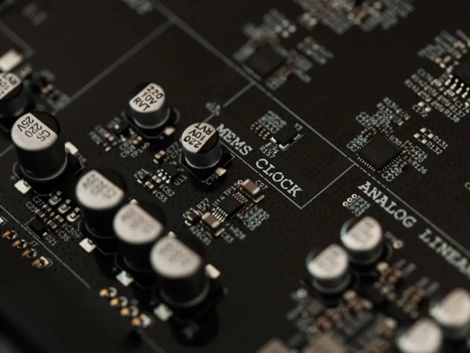 The Preciso circuit board seen at an angle, with MEMS CLOCK printed between rows of capacitors.