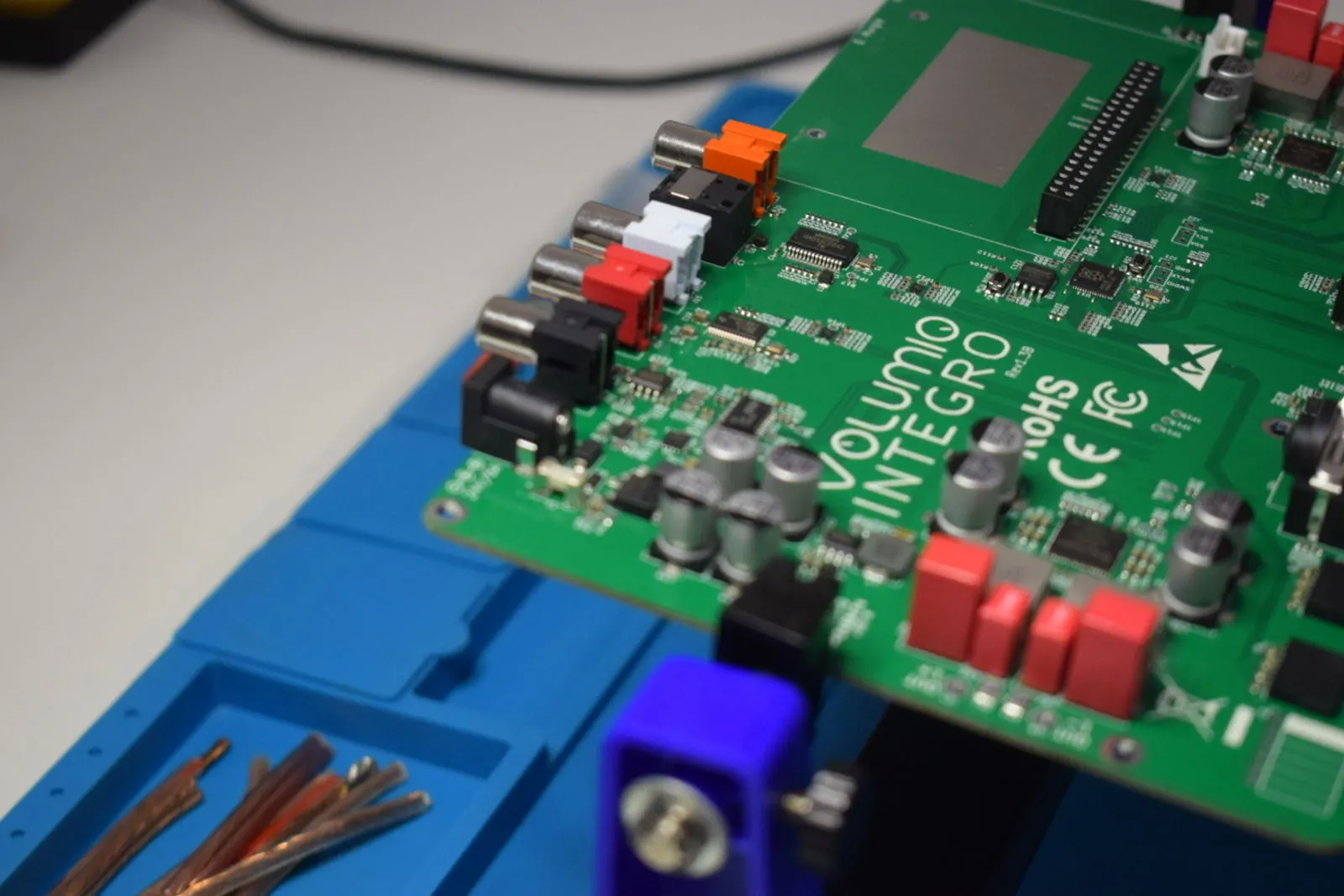 A close-up of the Integro circuit board, printed with the Volumio Integro name, on a blue work mat.