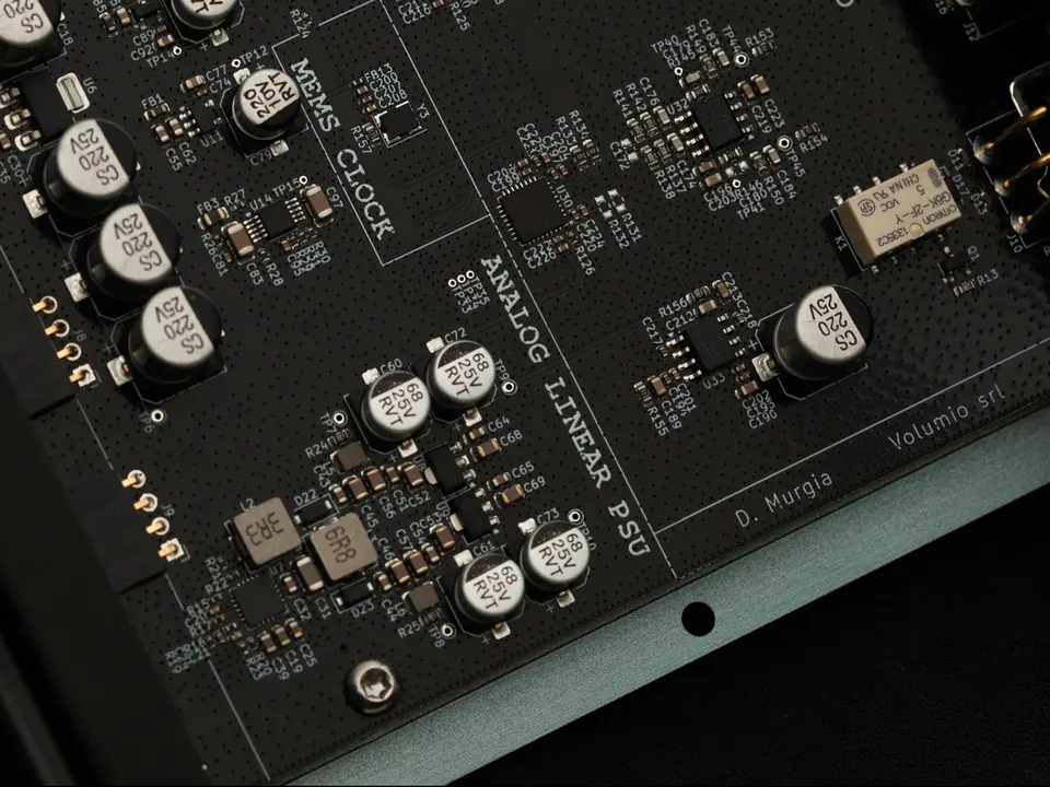 A close-up of the Preciso circuit board, with MEMS CLOCK and ANALOG LINEAR PSU printed between capacitors and chips.